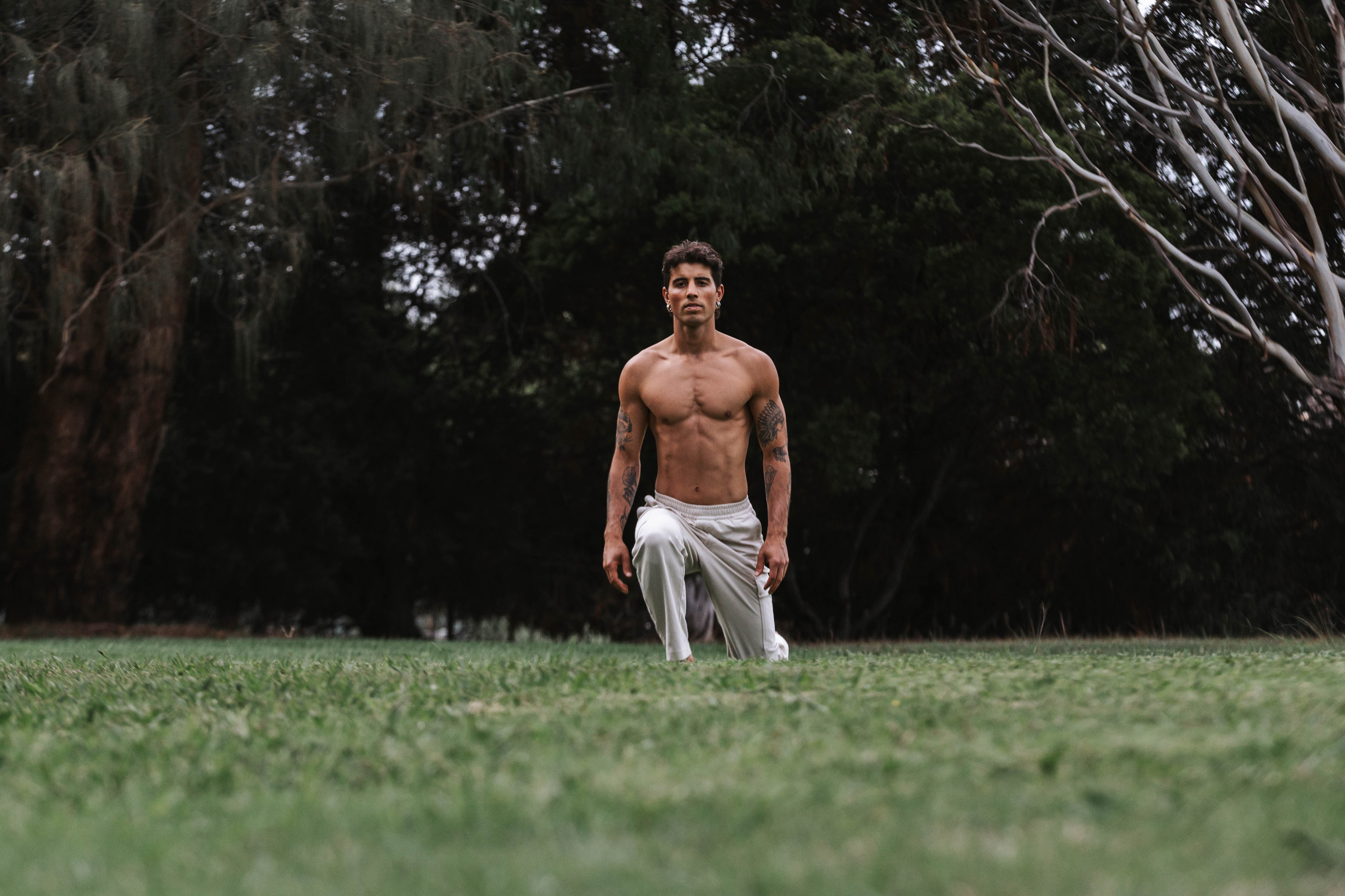 Tristan in a grounded movement stance on grass, evening light